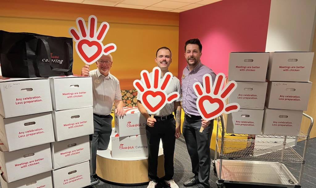 Seth Wilson with team members holding heart signs